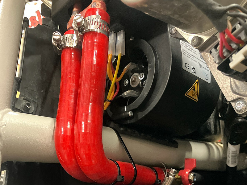 Ice Crusher heater unit installed under the dash of a Can-Am Maverick X3 with coolant hoses connected