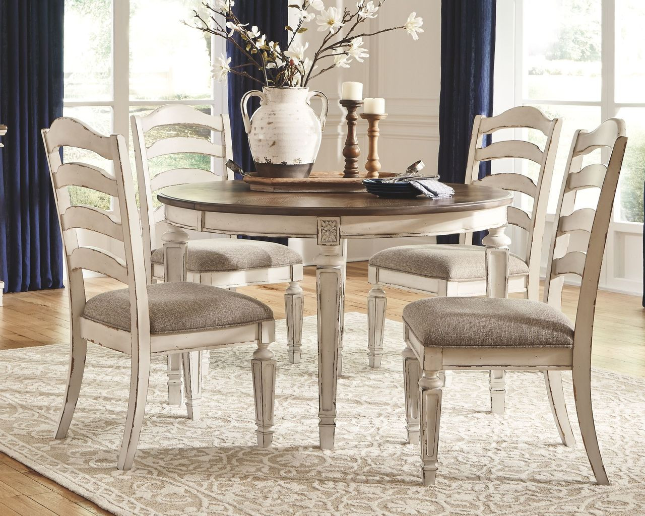 The Realyn Chipped White 5 Pc Oval EXT Table 4 Upholstered Side