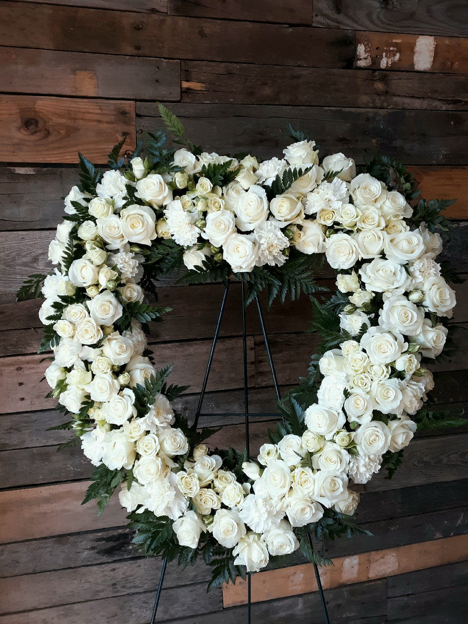 Heart shaped memorial wreath with pink roses and white stocks