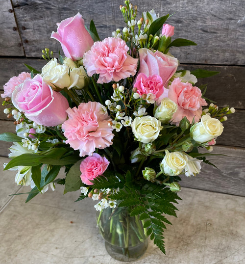 Pink roses, pink alstromeria, white mums and white statice in a sparkling glass vase