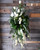 A unique standing spray with a graceful display of white roses and a bow made with fresh greenery.