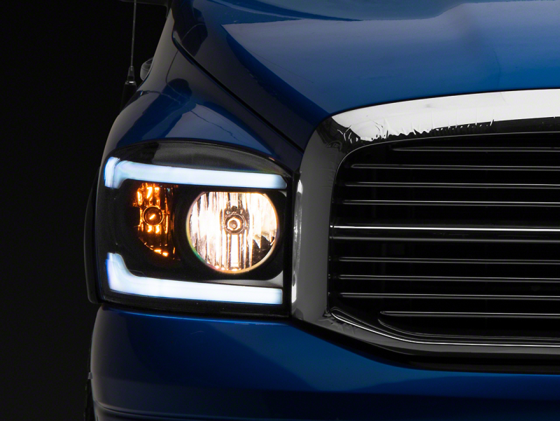 Raxiom 06-09 Dodge RAM 1500/2500/3500 Axial Headlights w/ SEQL LED Bar- Blk Housing (Clear Lens) - R131480