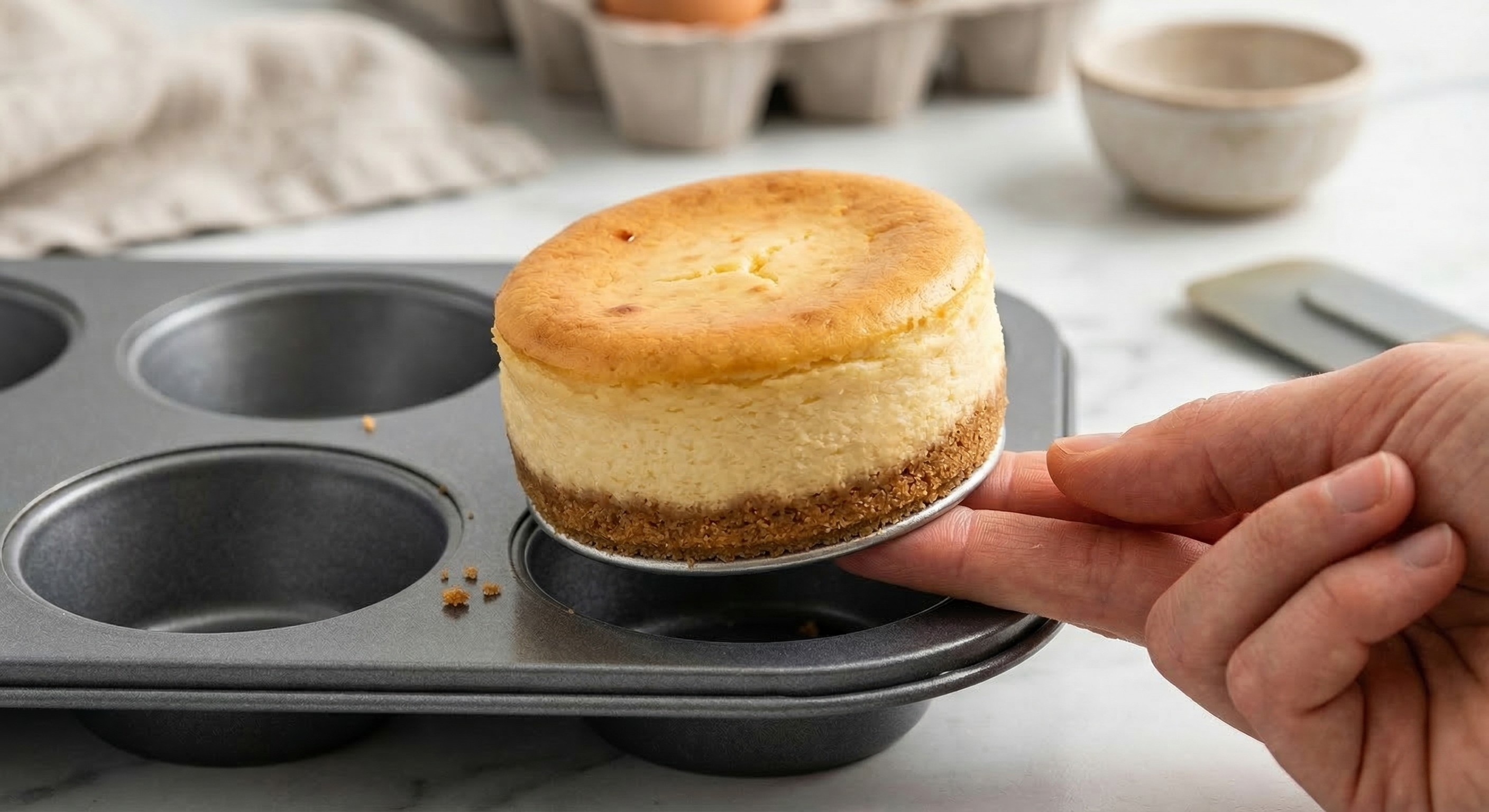 Pushing out a mini cheesecake from the loose base