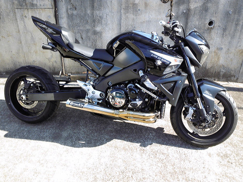<ul>
<li>Elliptical megaphone with removable street baffle</li>
<li>Show-polished finish</li>
<li>World class craftsmanship, fit, and finish</li>
<li>Dual 18mm O2 sensor bungs pre-installed</li>
<li>Oil cooler removal kit included; oil line kits for oil cooler use available (sold separately)</li>
<li>Fairing modifications required; installation hardware and instructions included</li>
<li>Includes (Emissions/PAIR) Block Off Cap and instructions for decel-pop reduction</li>
<li>May be used with OEM oil pan; aftermarket billet pan suggested for maximum ground clearance</li>
<li>Patented Design</li>
<li>Includes Brock&rsquo;s lifetime direct support package <em>at no additional charge</em></li>
<li><a style="color: blue;" href="%%GLOBAL_ShopPathSSL%%/product_images/uploaded_images/Logo_Plates_Article_Page_Display.jpg" target="_blank">Click here to view logo plate color options</a></li>
</ul>
<div class="moretab" data-title="Product Details">
<p><strong>Titanium Sidewinder Performance Exhaust System</strong></p>
<p>Brock's Performance patented TiWinder&trade; Full Titanium &lsquo;Elliptical&rsquo; Sidewinder for the Suzuki B-King. World-class engineering and craftsmanship are combined with exotic materials to produce an exhaust system second to none.</p>
<p>Developed for use in conjunction with 1&rdquo; deep aftermarket oil pans, utilizing our &lsquo;elliptical&rsquo; megaphone outlet for maximum ground clearance during the hardest chassis-dragging launches. This additional ground clearance also makes our patented TiWinder&trade; more user-friendly during cornering as a result of the best right hand clearance on the market. Note: Stock oil pan may also be used.</p>
<p>Utilizing our industry-first 4-2-1 Sidewinder configuration, the patented TiWinder&trade; outperforms any other system we have ever tested/manufactured not only on the dyno, but, more importantly, during real world drag strip testing. Stock displacement to BIG CC &lsquo;mountain&rsquo; motors benefit alike from maximum peak AND average horsepower combined with a smooth linear torque curve throughout the entire rev range from launch to limiter. Constructed of a combination of pure and exotic titanium alloy tubing, we offer the first aftermarket production motorcycle exhaust system in the world to use high-temperature titanium alloys in critical areas to handle the extreme temperatures generated by the use of nitrous oxide. The &lsquo;grudge&rsquo; crowd will be happy to hear that the entire system only weighs 5.3 lbs. without the baffle.</p>
<p>Spring-mounted utilizing our &lsquo;big cc&rsquo; stainless steel spigots with billet aluminum clamp plates for quick, between round maintenance and designed for use with stock or quick access clutch covers (modification to certain aftermarket covers required - consult our technical department for additional details).</p>
<p>Dual O2 bosses allow independent air/fuel measurements in head pipes 1&amp;2 and/or 3&amp;4 for more precise cylinder &lsquo;trim&rsquo; measurements.</p>
<p>System includes replacement laser-cut stainless steel lower radiator mounting bracket, and a longer rear brake clevis to allow use of your stock rear brake lever. Right side fairing modifications required; instructions included. Ask anyone who has picked up one of these works of art&hellip; &rdquo;WOW!&rdquo; and &ldquo;DAMN!&rdquo; are the most used terms.</p>
</div>
