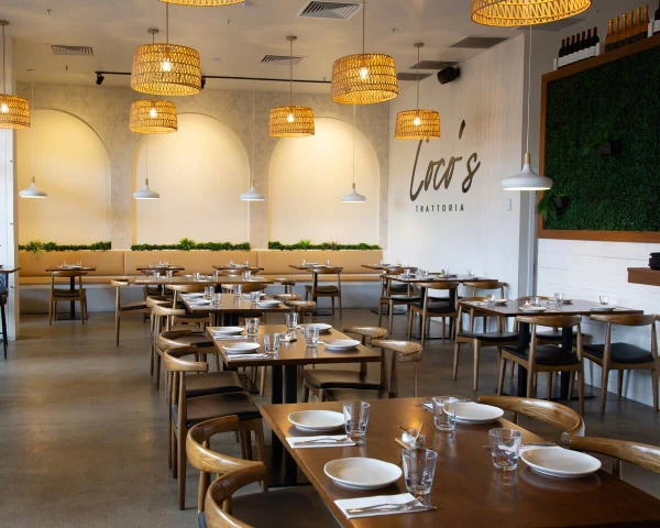 Coco’s Trattoria dining area furnished with walnut Elbow chairs, solid oak restaurant table tops and black pedestal table bases.