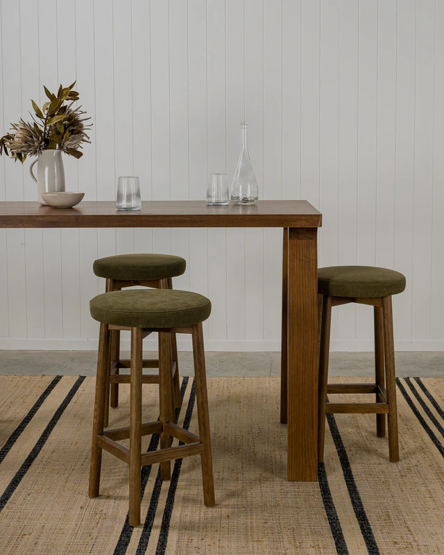 Dark oak bar stools with an upholstered seat paired with a dark oak bar table