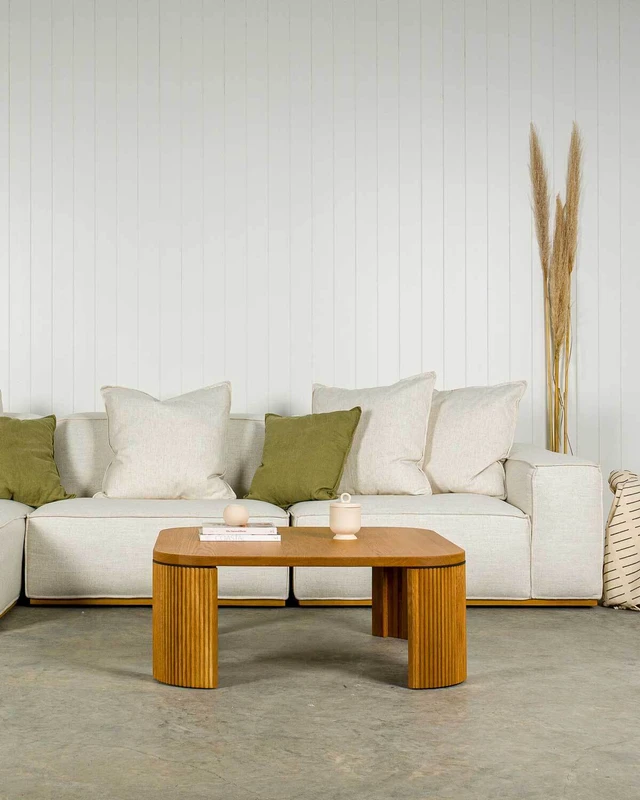 Hayes modular fabric sofa with oversized cushions, paired with the Reid oak coffee table with rounded top and distinctive fluted legs.