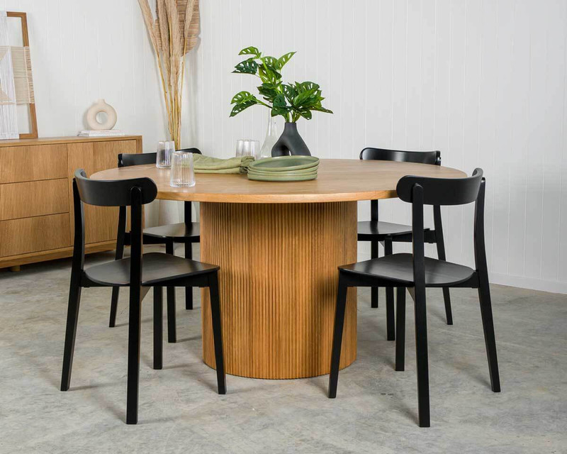 Round timber dining table setting with black dining chairs