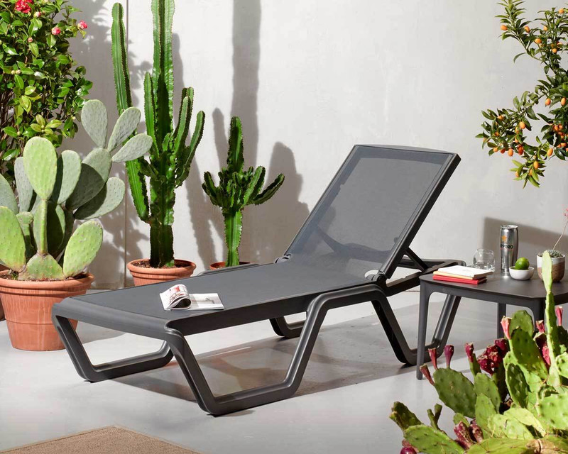Vela sun lounger in an outdoor setting with side table