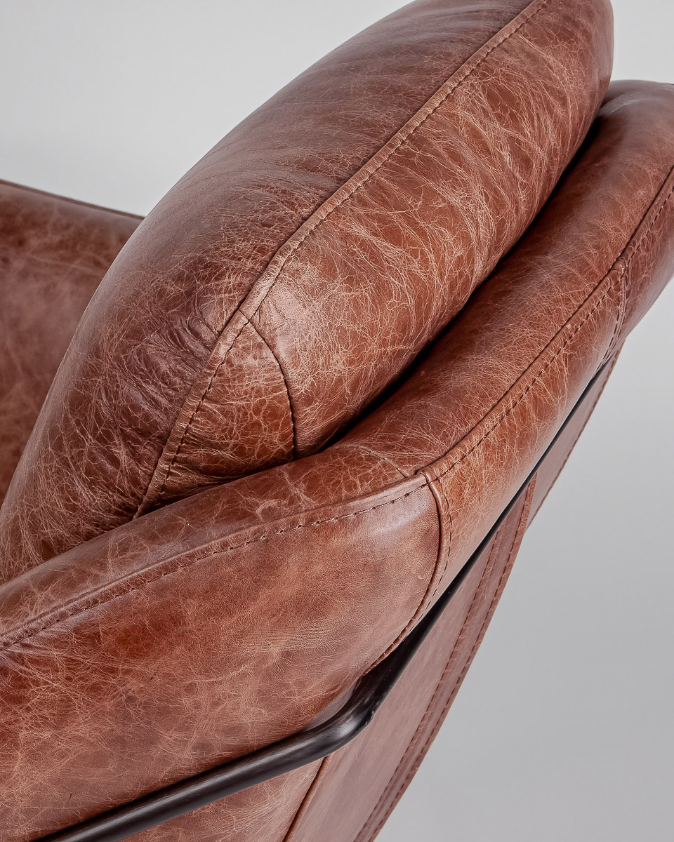 Close up of tan leather armchair with detailed stitching
