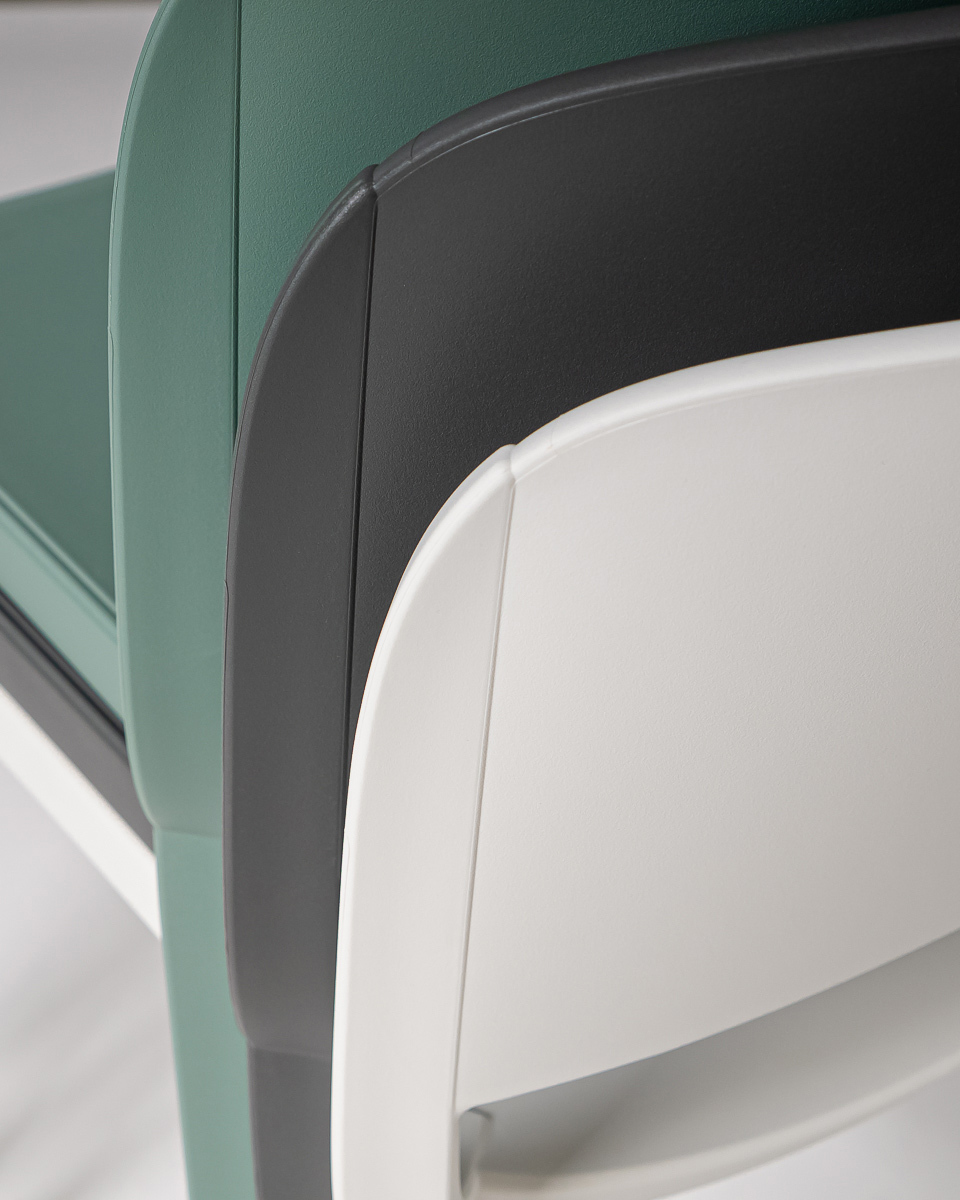 Stacked polyprop chairs in green, grey and white.