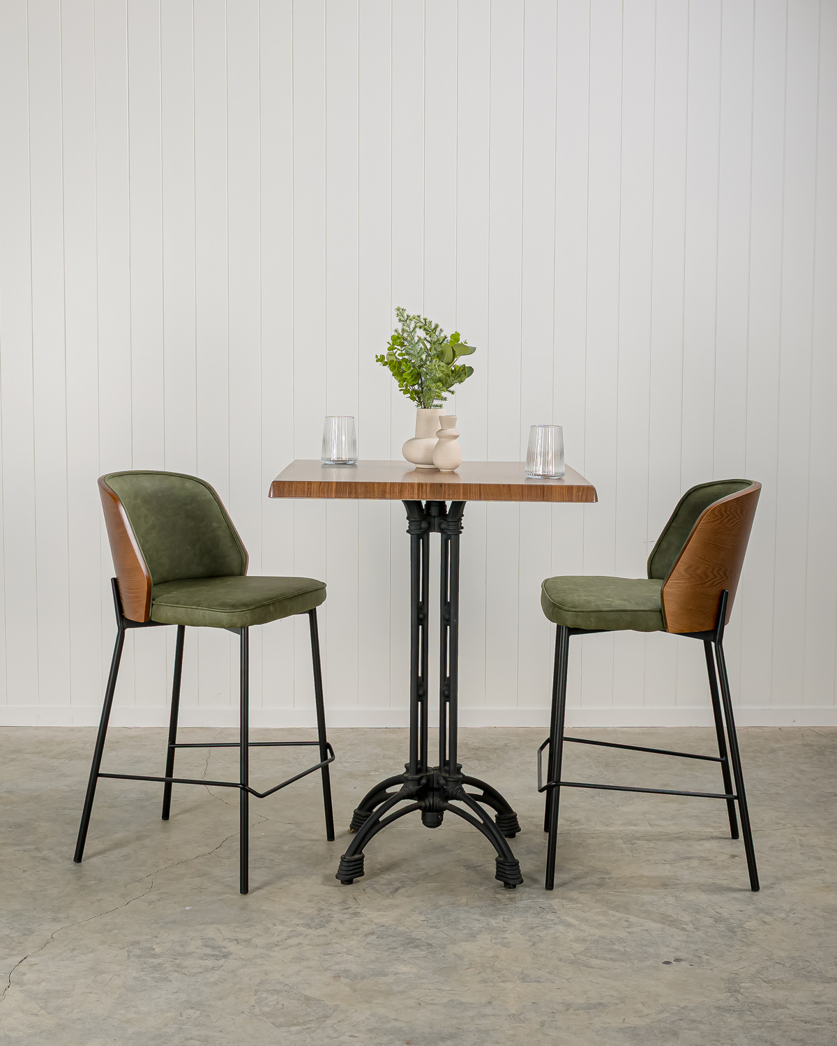 Clive upholstered bar stools paired with a Rita cast iron table base and Toulouse timber table top in a contemporary hospitality setting.