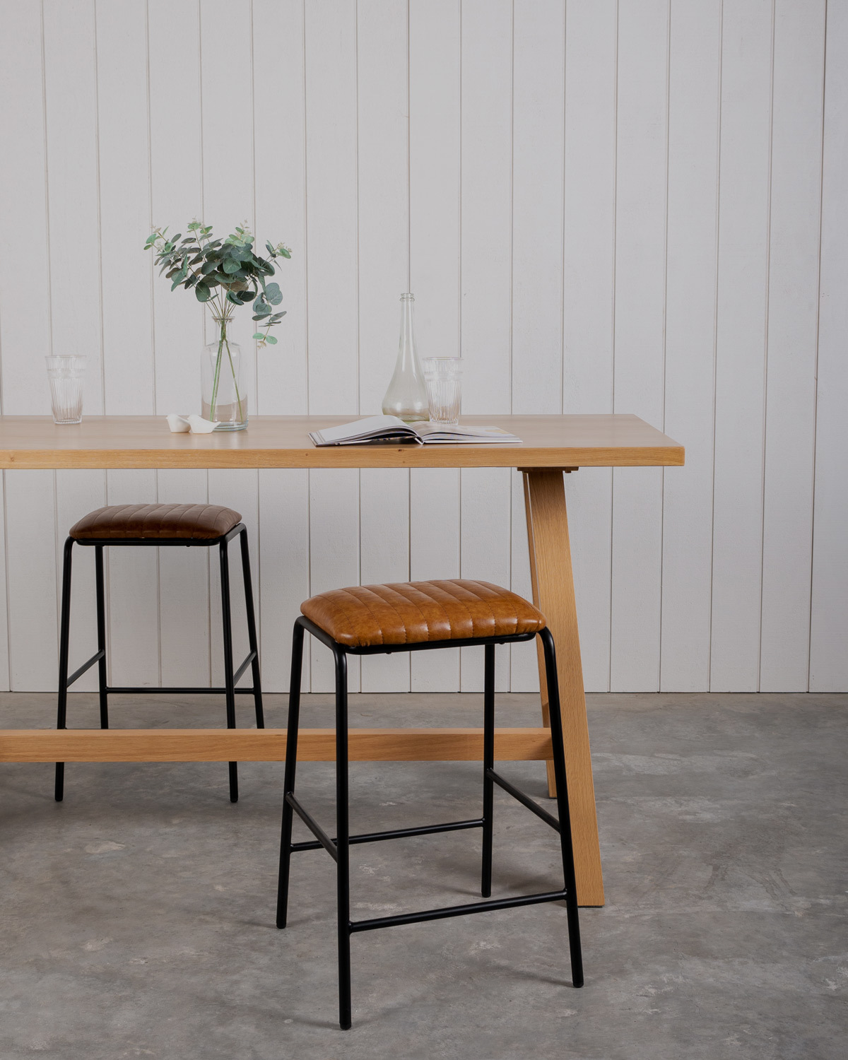 Idaho bar leaners in natural oak paired with a Bruce insdustrial style stool with black frame and tan seat pad