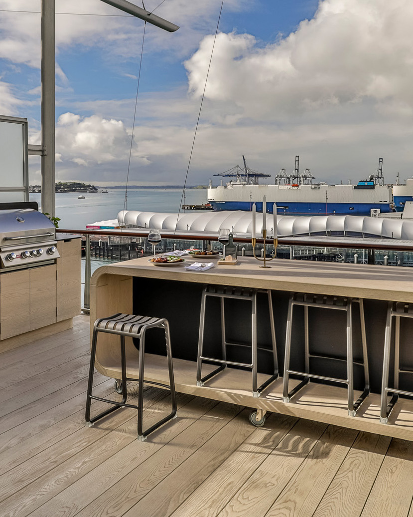 Atticus aluminium bar stools styled around an outdoor waterfront bar leaner in a modern penthouse apartment overlooking the harbour.