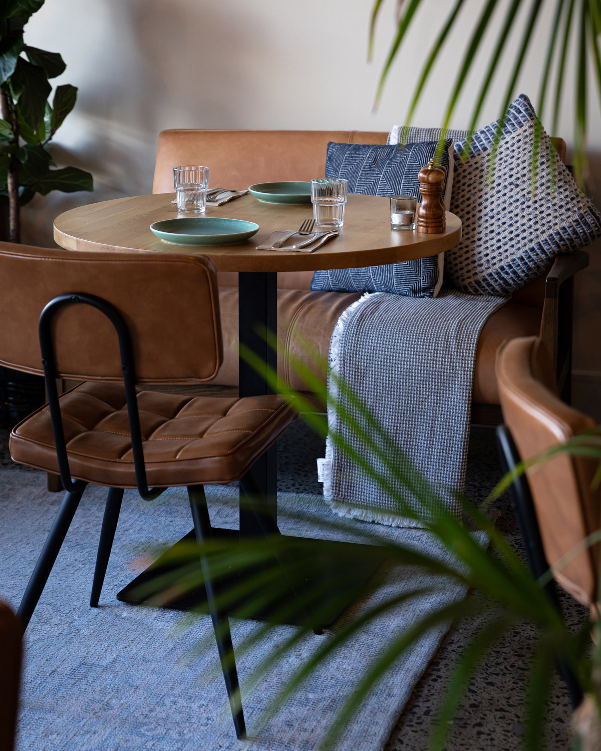 Konus black square table bas paired with a natural timber table top in a restaurant setting