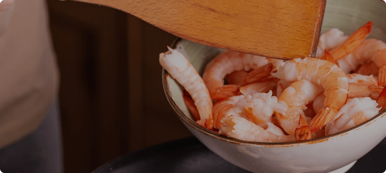 A batch of shrimp cooking in a skillet