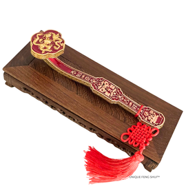 Feng Shui Ruyi Scepter displayed on a wooden stand with red tassel