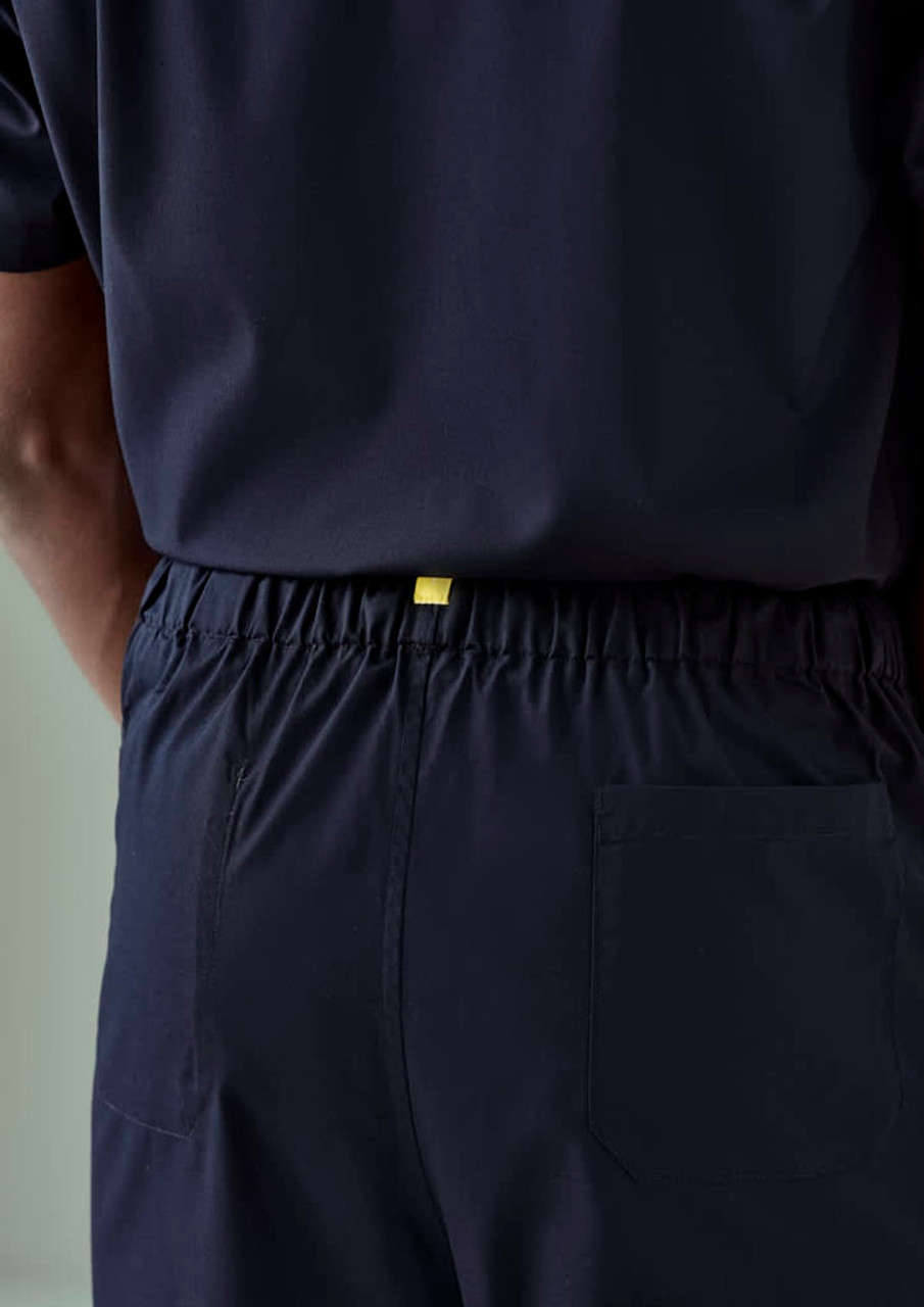 Navy unisex scrub pants with an elastic waistband and a back pocket, featuring a branding tag.