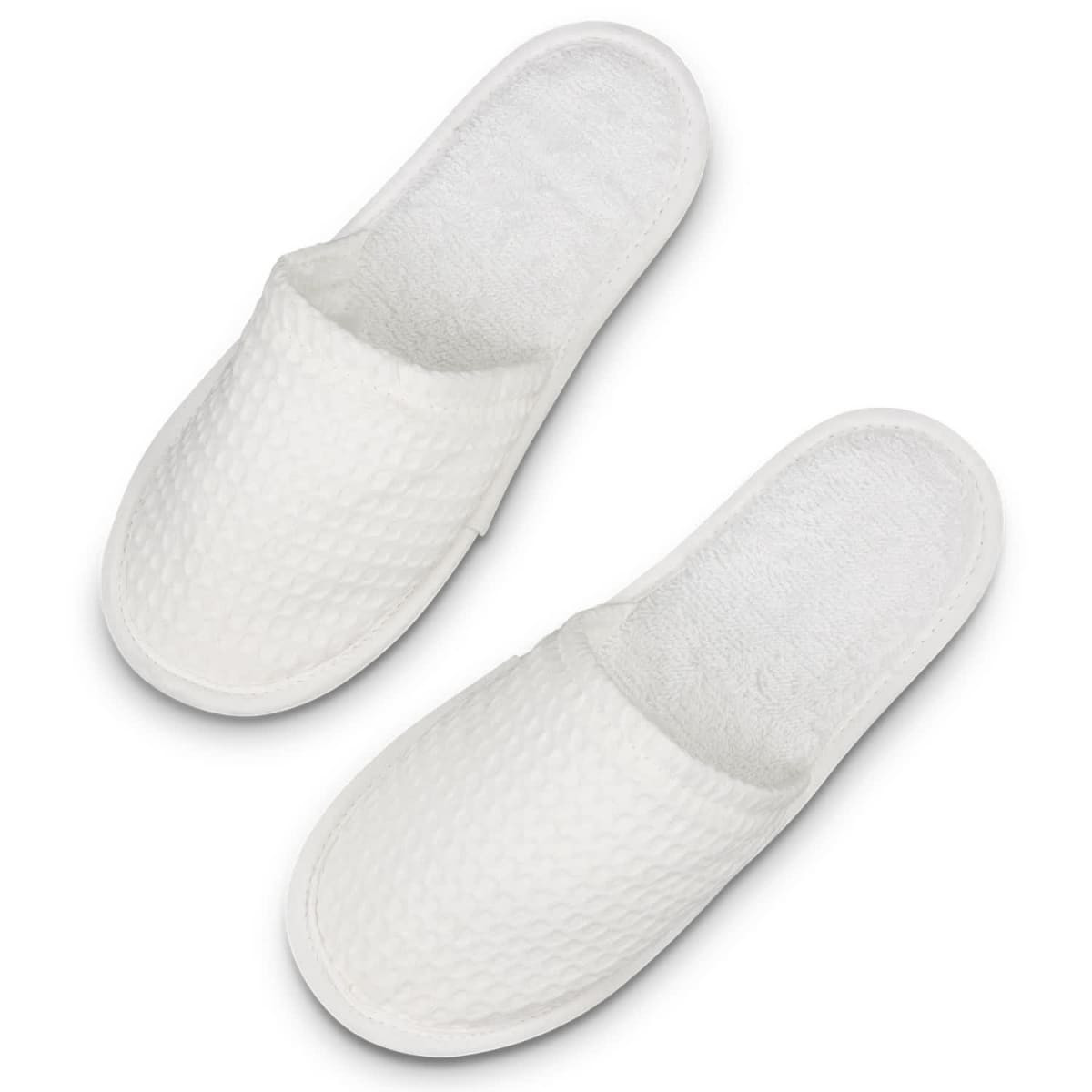 A pair of white waffle slippers with a textured surface and a soft, plush interior.