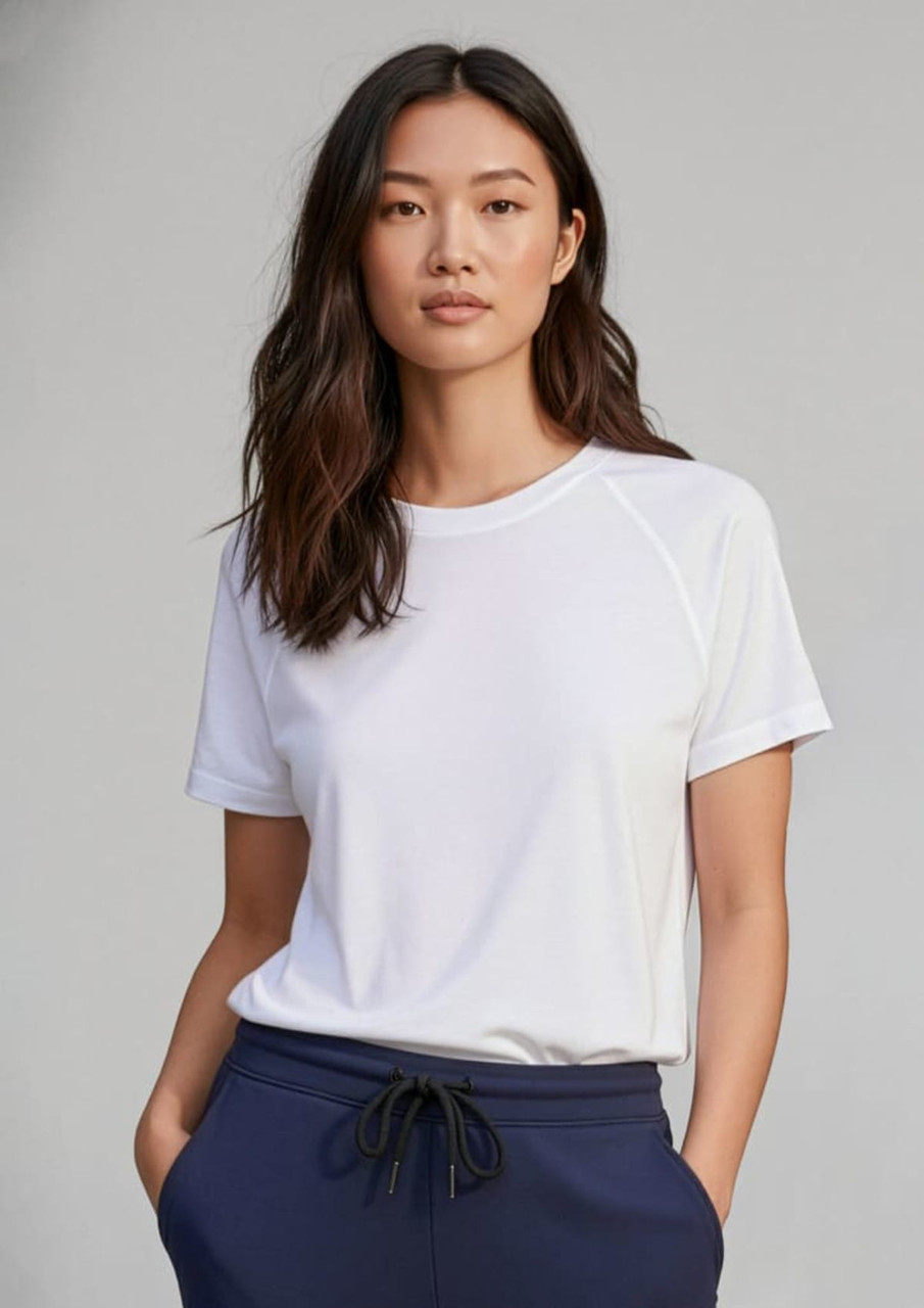 A white short sleeve tee with a relaxed fit, featuring a logo and styled with navy blue bottoms.