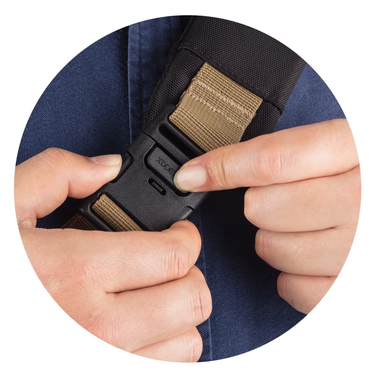 A hand adjusting a buckle on a strap, showcasing a dark fabric and a tan webbing. The image has a circular frame.