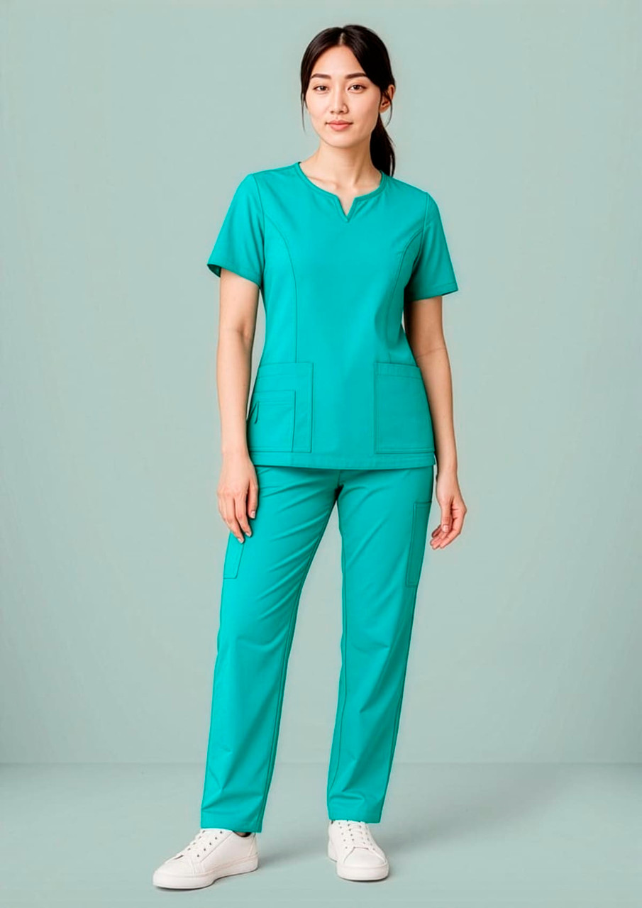 A women's scrub top in teal, featuring a round neck and two front pockets, styled with matching pants.