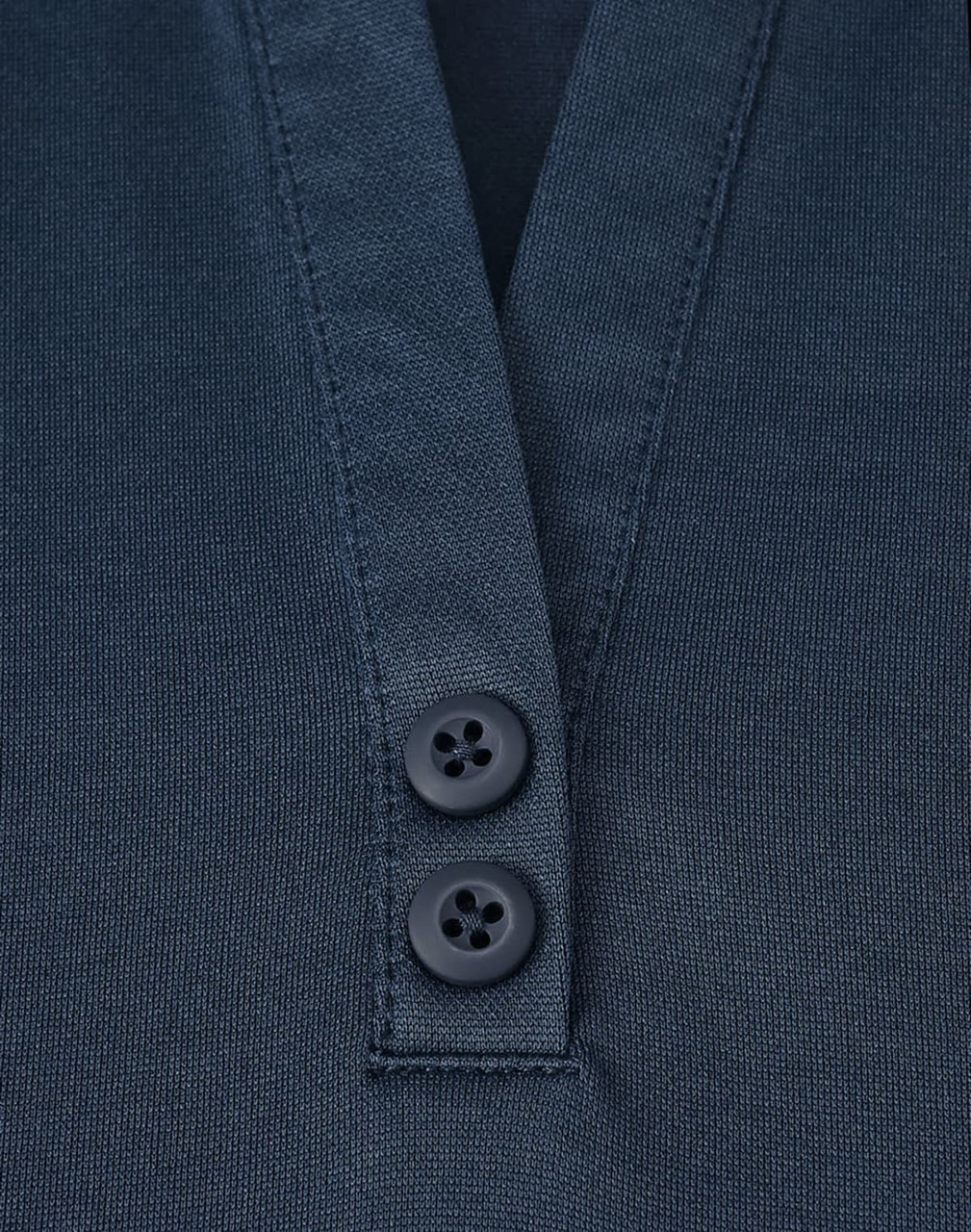 A close-up of a navy blue polo shirt featuring a V-neck and two buttons. The fabric appears sustainable.