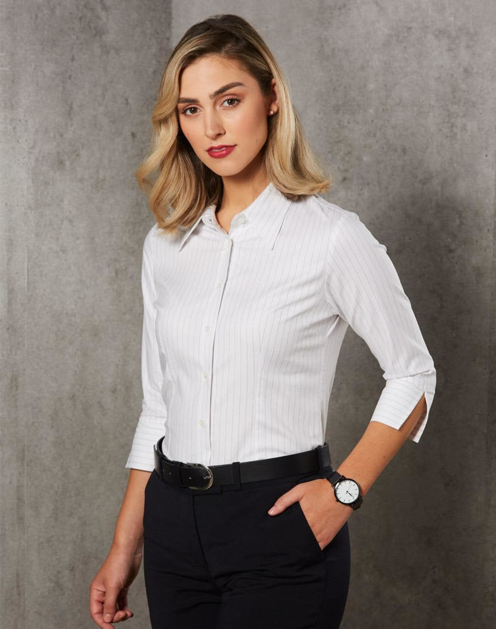A white striped button-up shirt with long sleeves and roll-up detailing, paired with dark trousers and a watch.