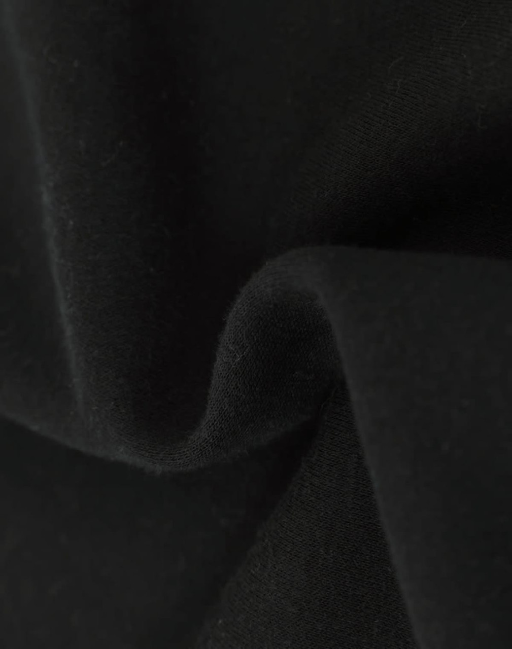 A close-up of soft, black fabric showcasing a textured surface, indicating a fleece material.