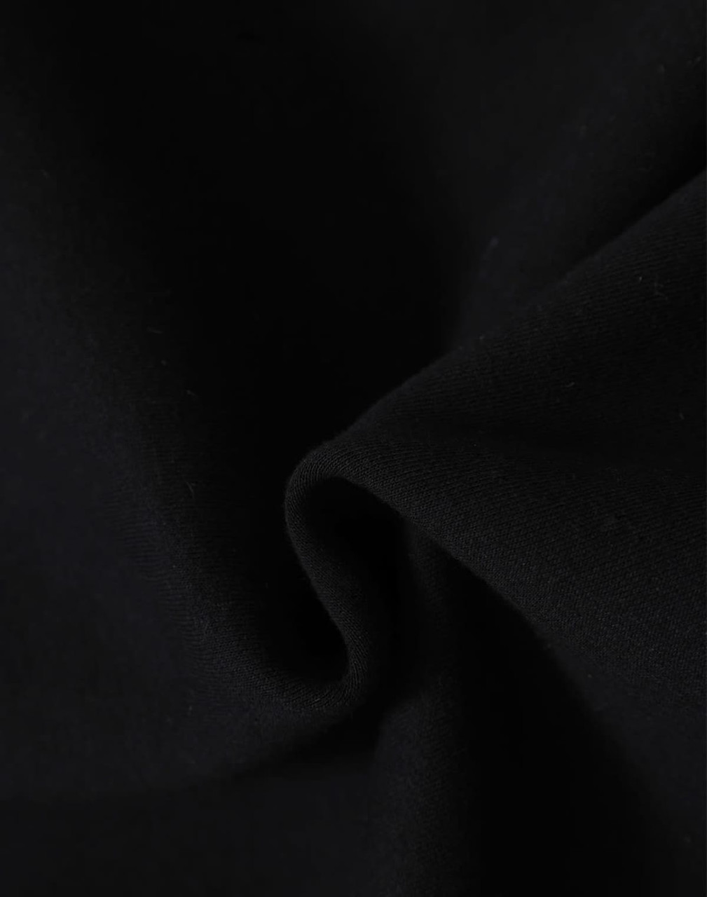 A close-up of black fabric, showcasing a soft, fleecy texture. The material is ideal for apparel like hoodies.