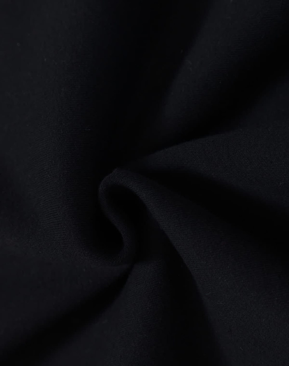 A close-up of black fabric with a soft texture, demonstrating a fleecy material suitable for hoodies.