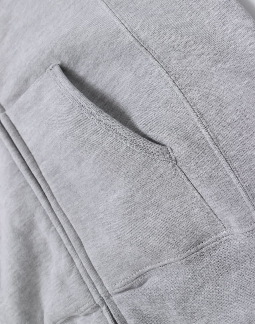 A grey ladies' full-zip fleecy hoodie featuring a front pocket and soft fabric texture. The hoodie has a branding logo.