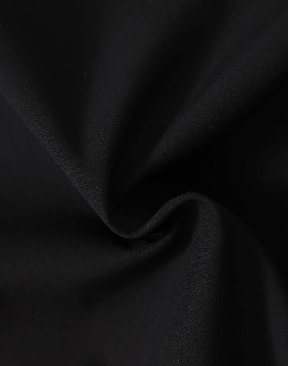 A close-up of black fabric featuring a soft texture, ideal for softshell jackets.