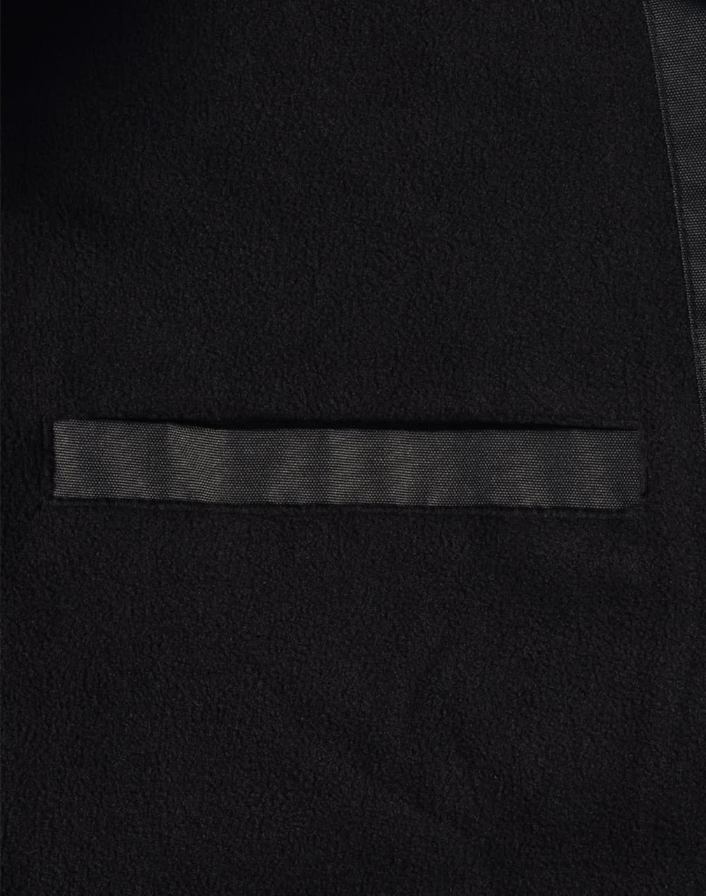 A close-up of a black long line stadium jacket featuring a sleek design and a pocket. The jacket has a branding logo.