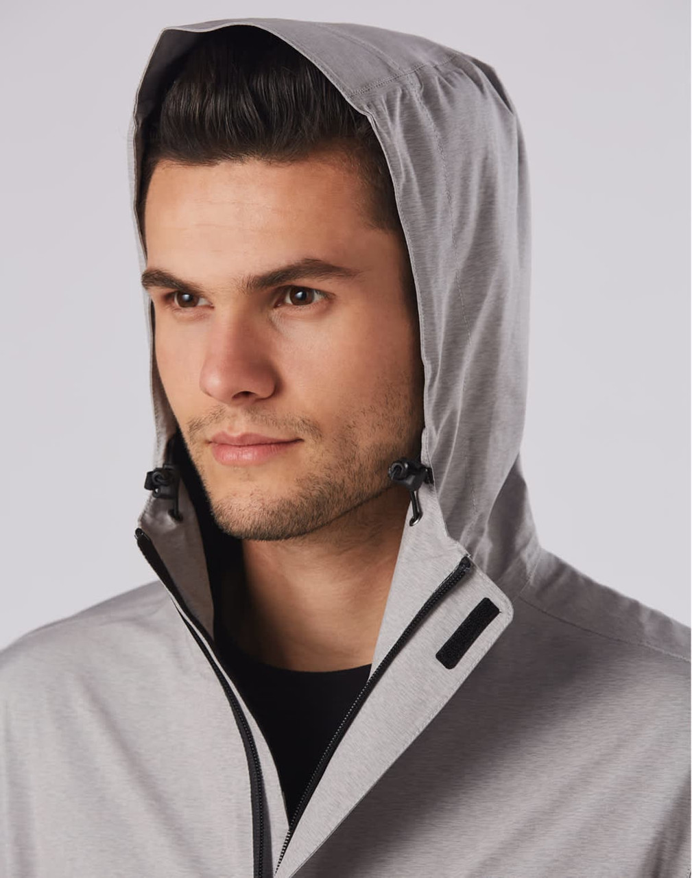 Men's waterproof performance jacket in grey, featuring a hood and branding. Suitable for rain protection.