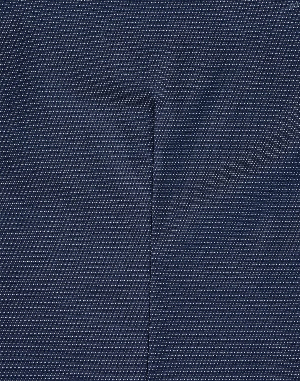 A close-up of a navy blue fabric with a pin dot pattern, showcasing the texture of the shirt.