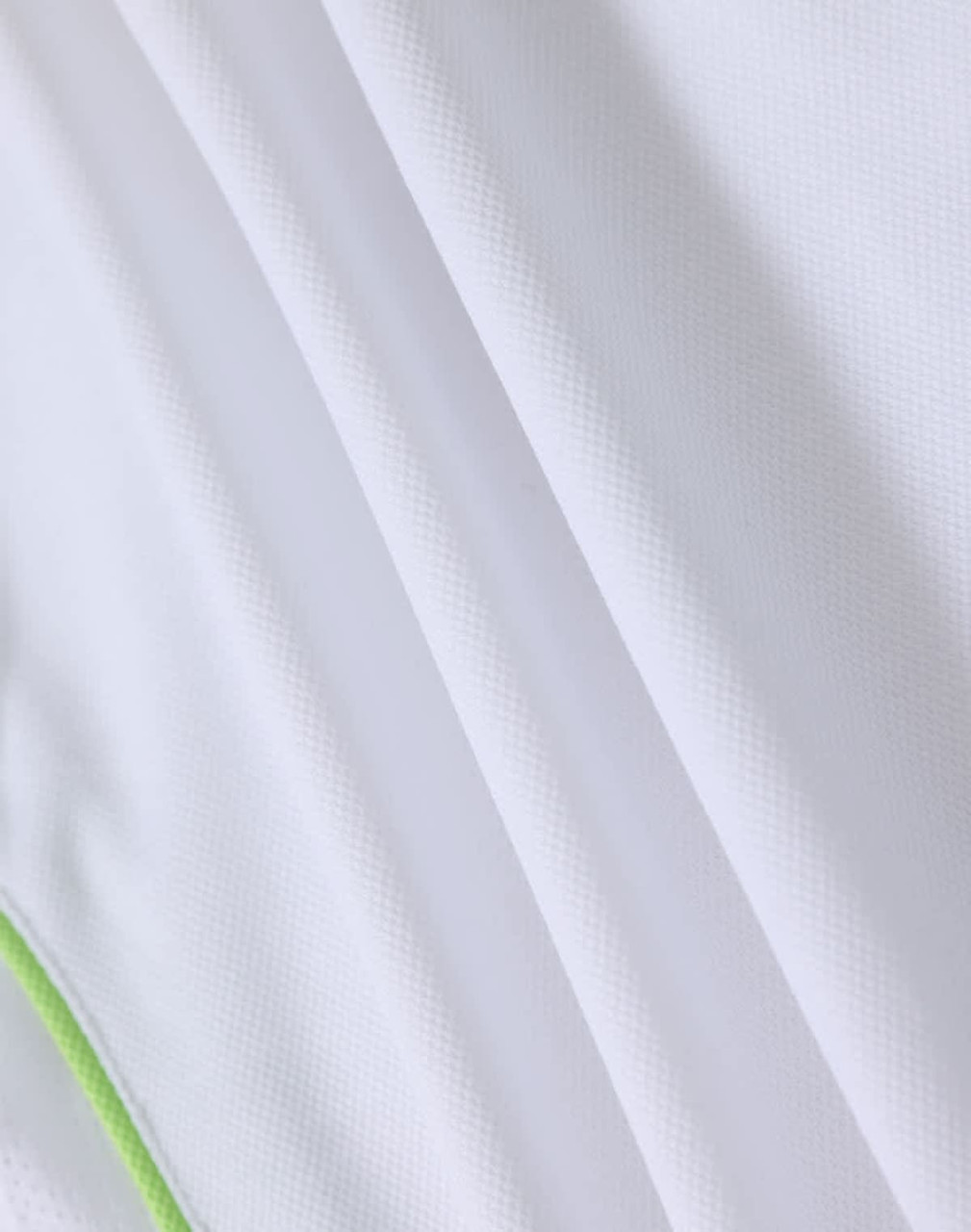 A white polo shirt with a green trim, featuring a textured fabric and a logo.