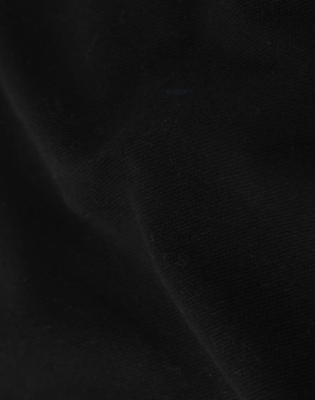 A close-up of black cotton fabric, showcasing its texture and softness suitable for apparel.