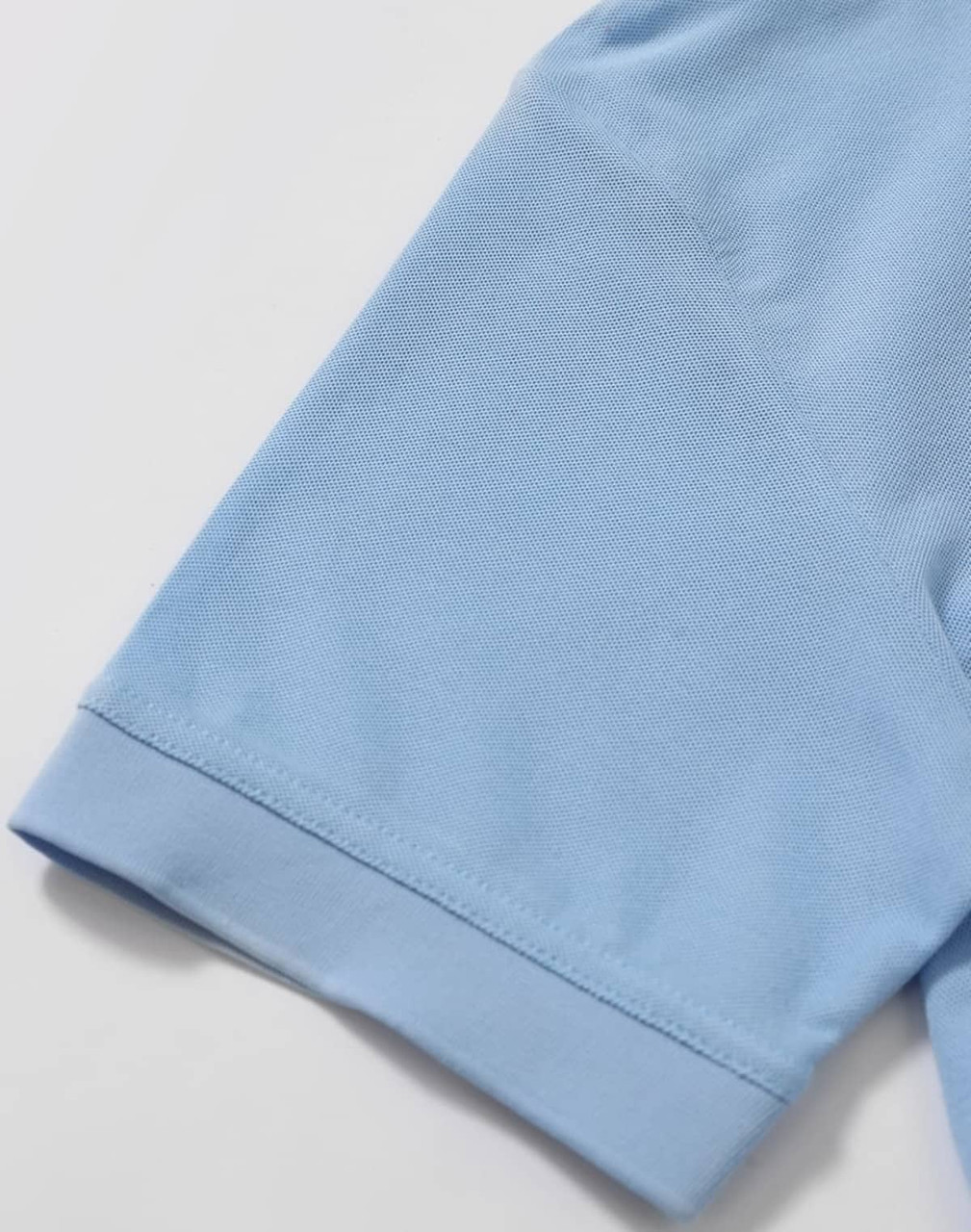 A light blue polo shirt sleeve featuring a smooth finish and a logo on the front.