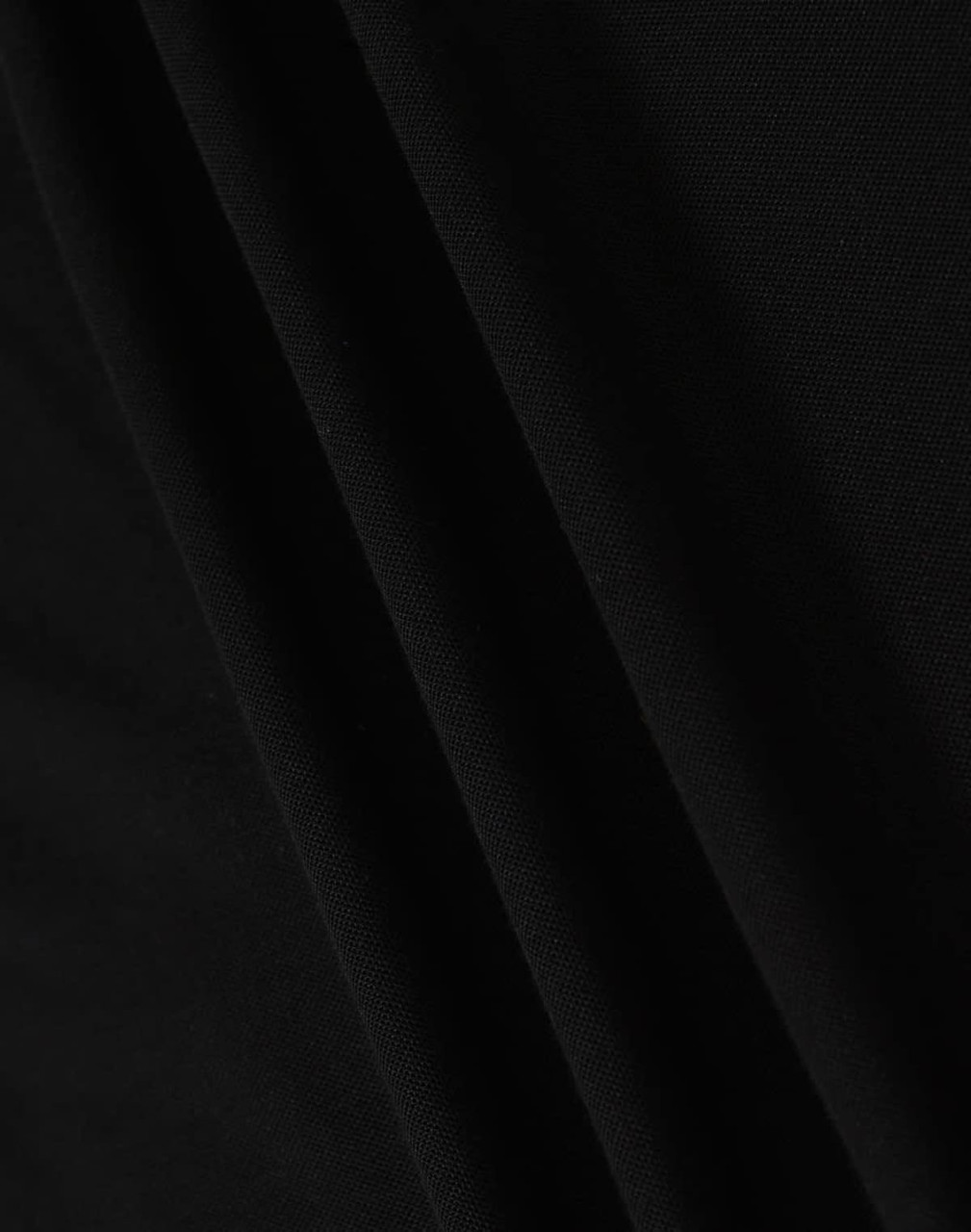 A close-up of black fabric, featuring smooth folds and a soft texture, ideal for a polo shirt.