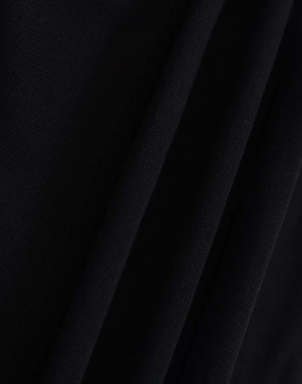 A close-up of a black fabric with a textured surface, featuring folds and draping. The image showcases the material's quality.