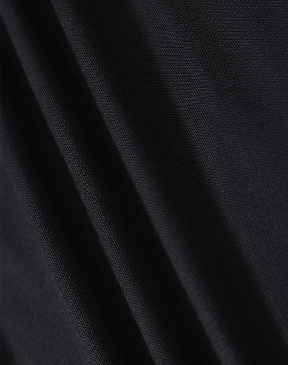 A close-up of black fabric showcasing the texture of a polo shirt. The material appears smooth and lightweight.