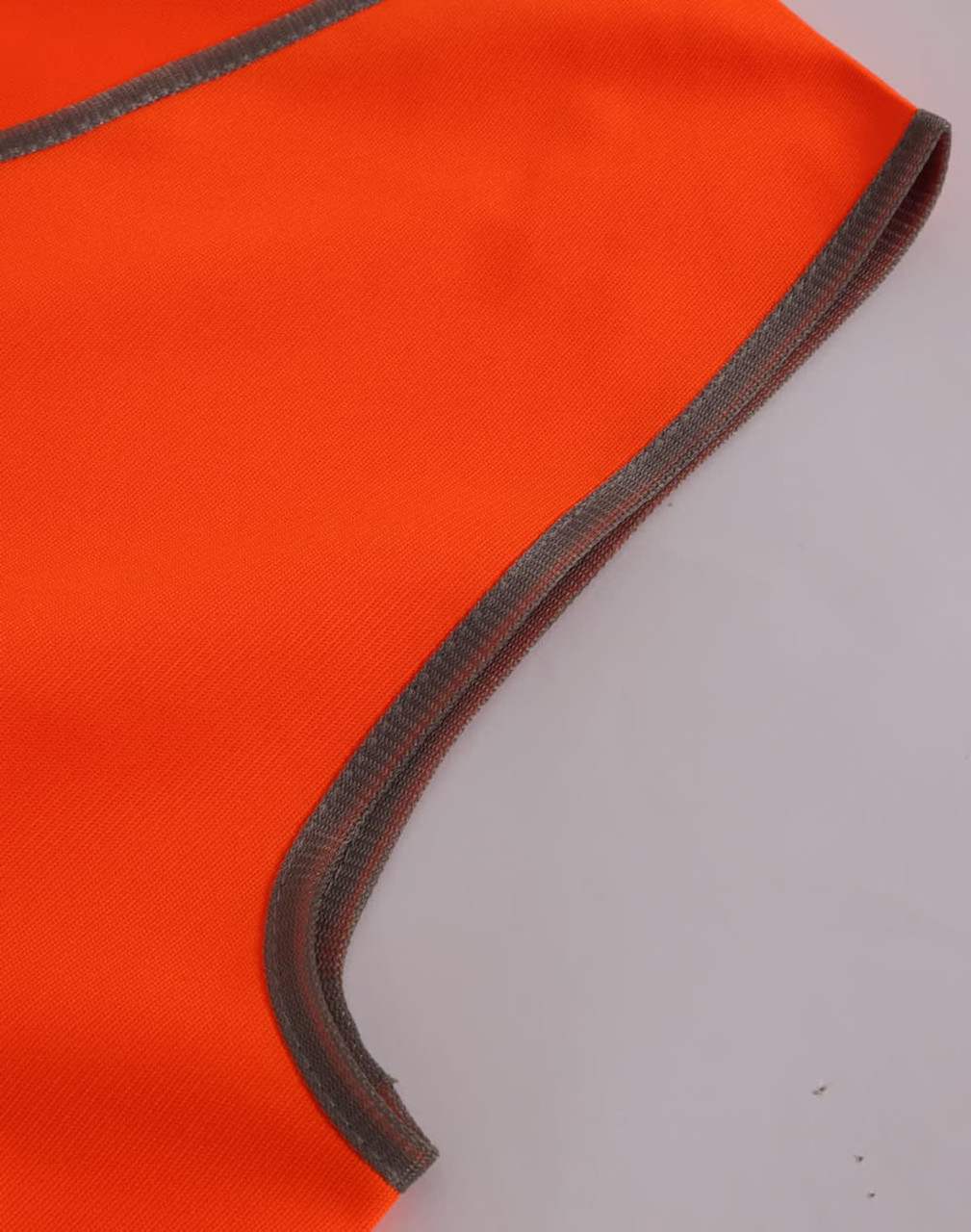 A close-up of a bright orange safety vest with grey trim, designed for children's safety wear.