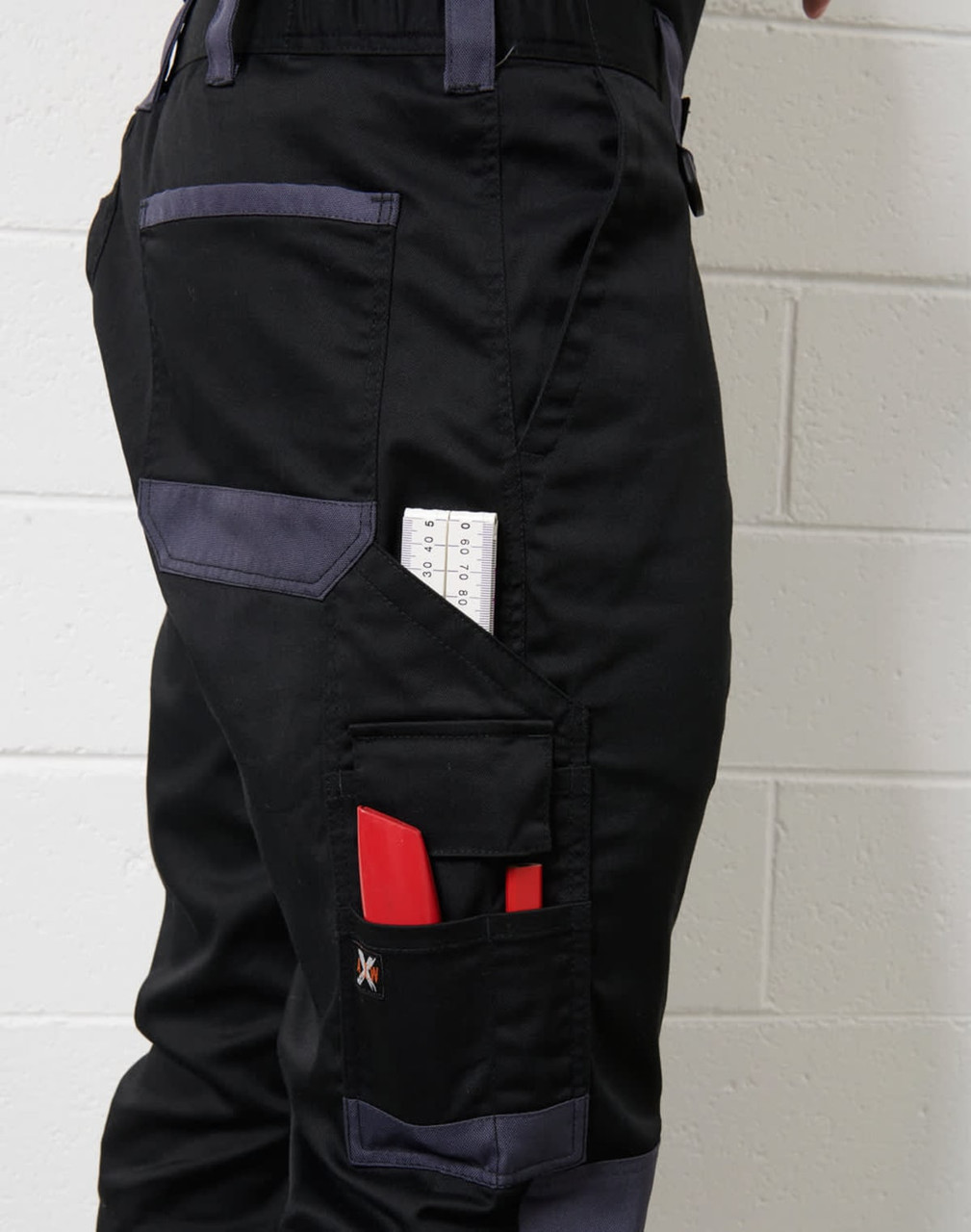 A pair of black unisex utility stretch cargo work pants with multiple pockets, including tool holders and a logo.