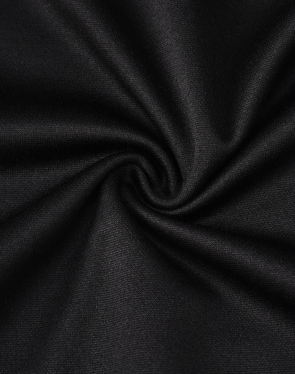A close-up of black fabric with a smooth texture, showcasing the sustainable poly/cotton blend.