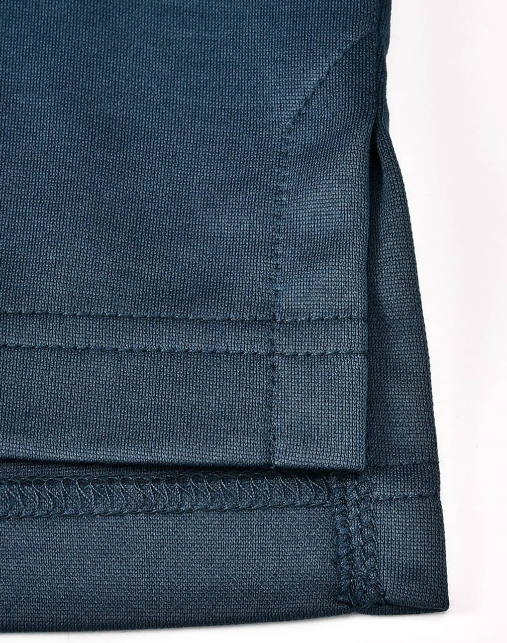 A dark teal men's sustainable poly/cotton polo shirt, showcased with a focus on the hem and sleeve detailing.