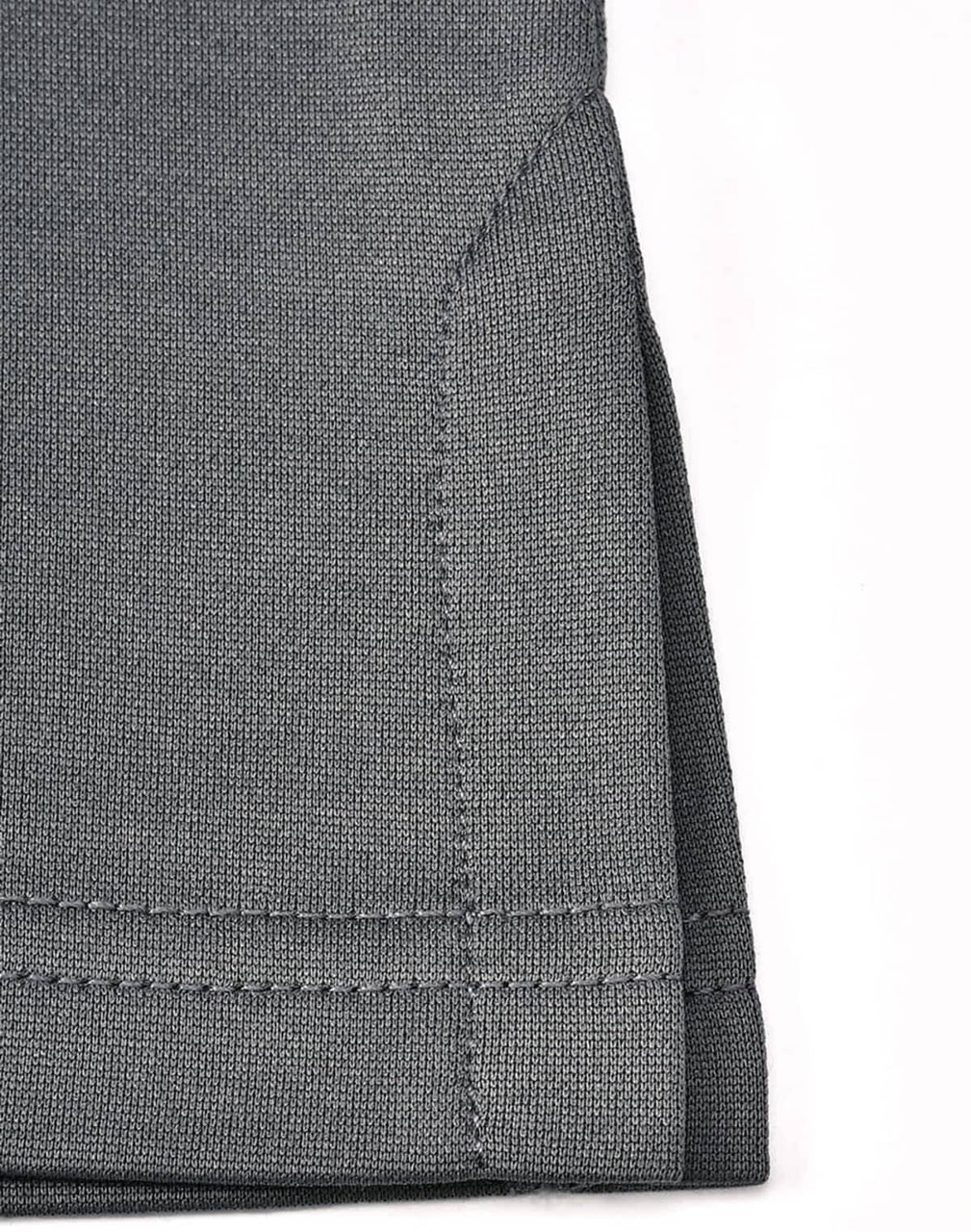 A close-up of the hem of a grey sustainable poly/cotton polo shirt featuring neat stitching and a folded edge.