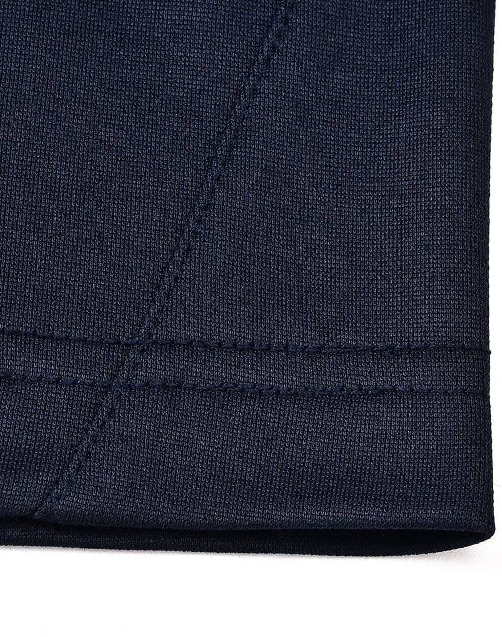 A close-up of the hem of a navy polo shirt showcasing the fabric texture and stitching detail.