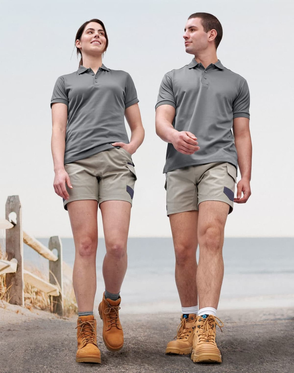 A pair of unisex cotton stretch drill short work shorts in light grey, worn by a male and female model.