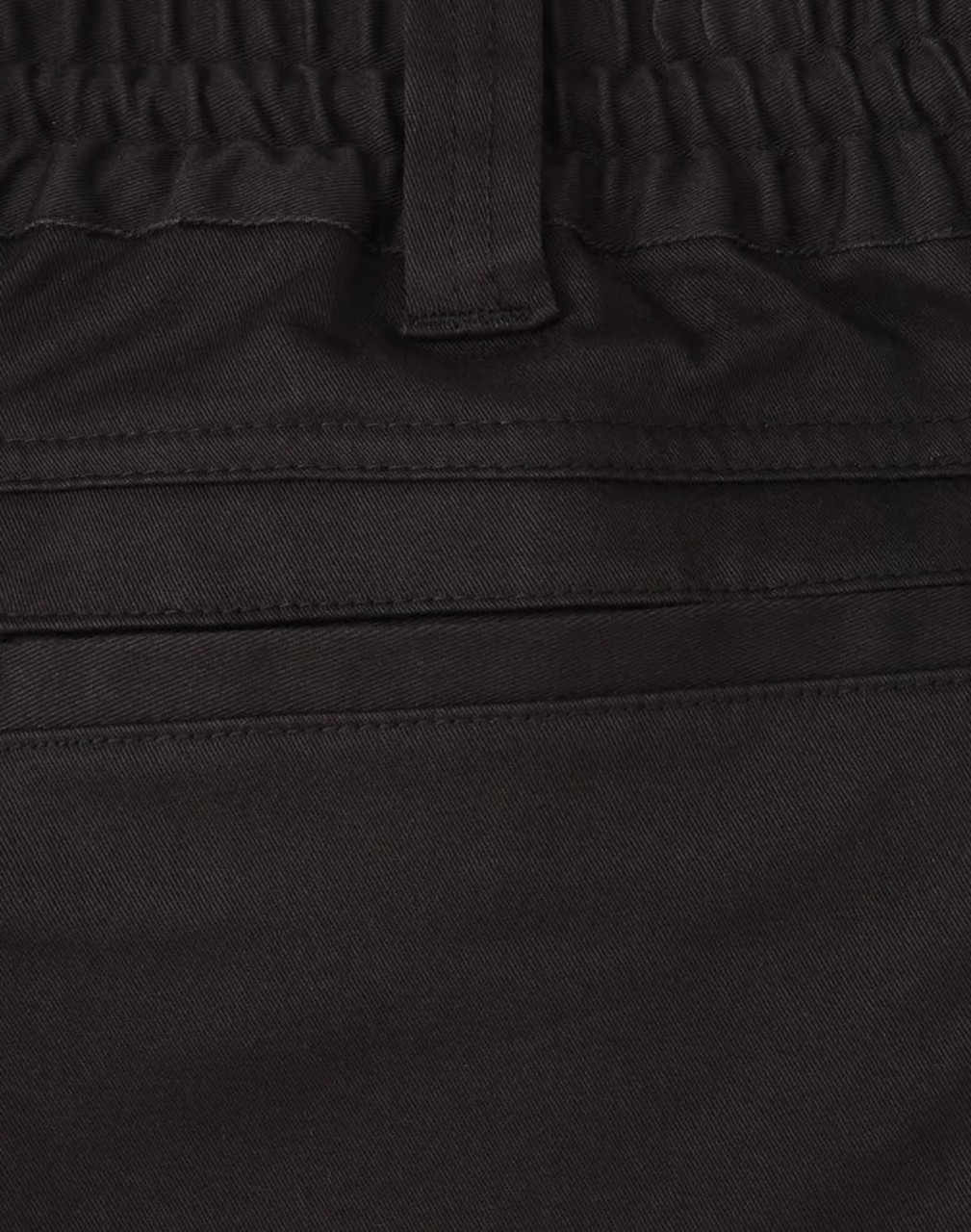 A close-up of black cotton stretch drill work shorts, featuring an elastic waistband and pockets.